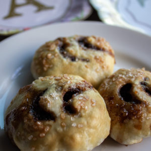 Baked Eccles Cakes, three, on a white plate.