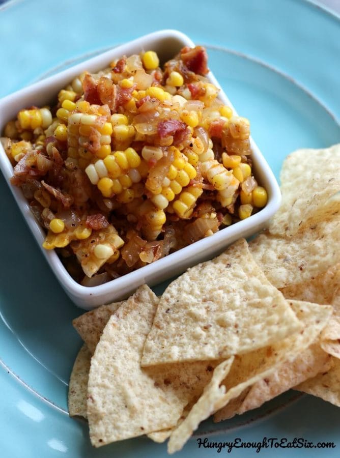Image of Corn, Vidalia Onion and Bacon Salsa in a square dish with tortilla chips.