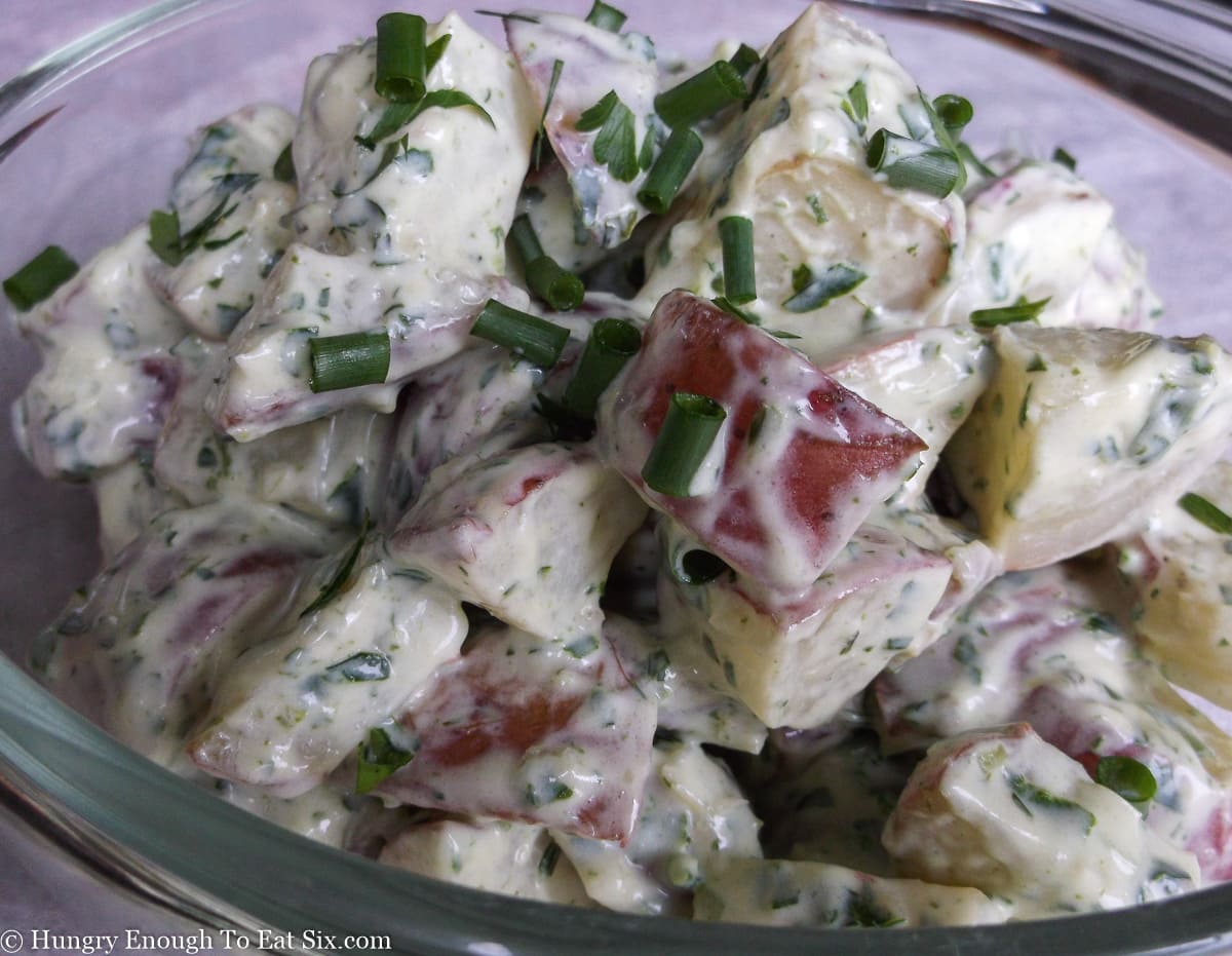 Glass bowl of potato salad in a creamy dressing