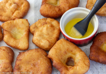 Fried dough next to a red bowl of melted butter