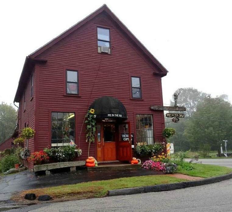 Large red house with awning and flowers. 