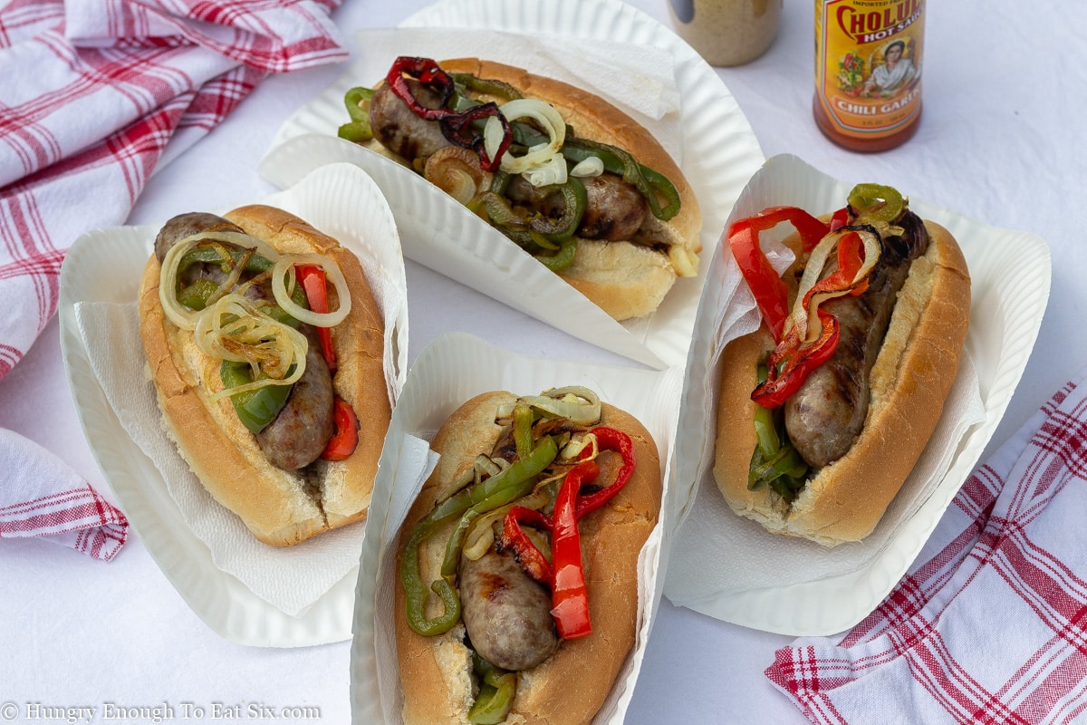 Grilled veggies over sausages in sub rolls.