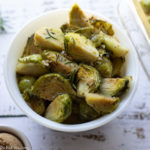 Brussels sprouts with rosemary in a white bowl.