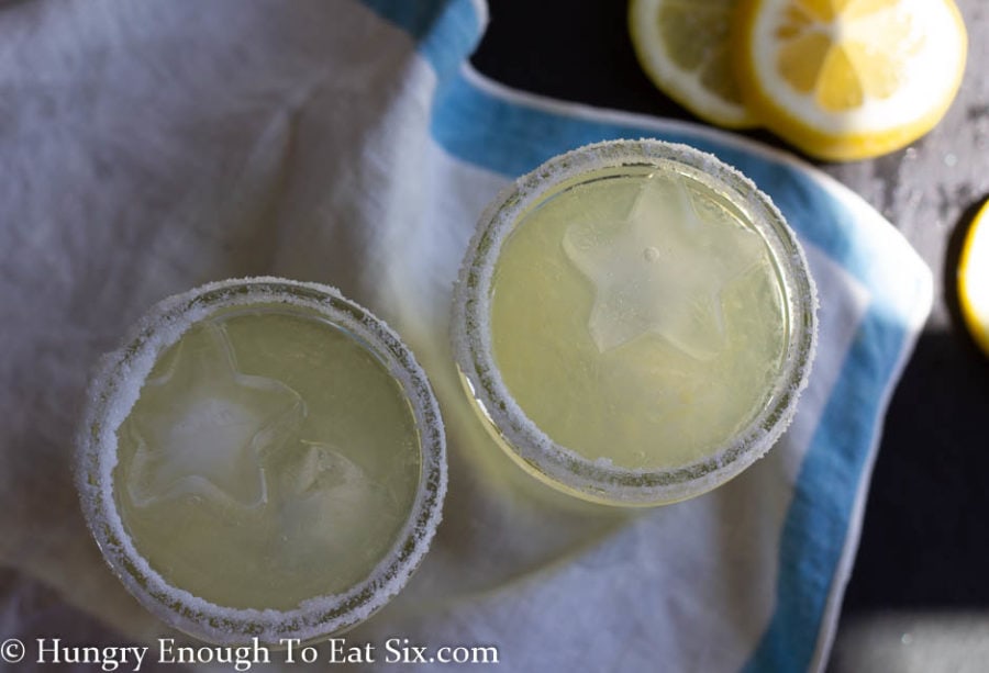 Overhead shot of lemon margaritas in small mason jars with salted rims.