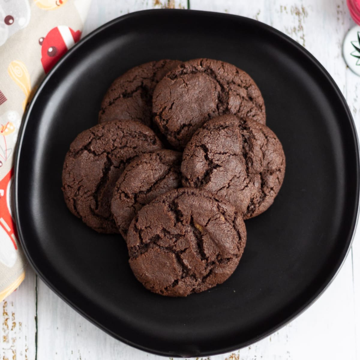Six chocolate cookies on a black plate