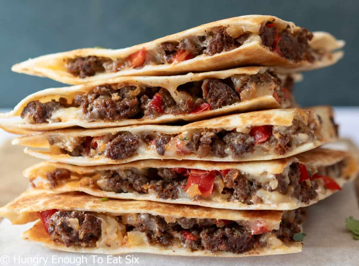Stacked and sliced quesadillas with meat and cheese filling.