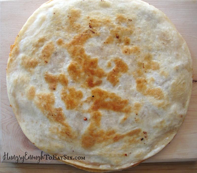 Round, griddled tortillas with cheese filling.