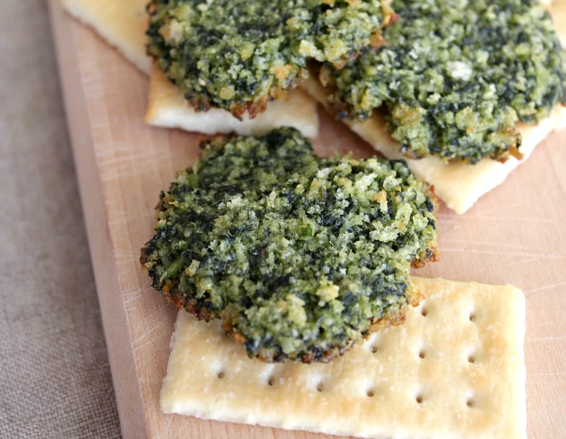 Mounds of baked pesto with a cracker.