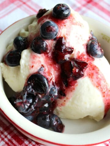 Lemon ice cream in dish with berries.