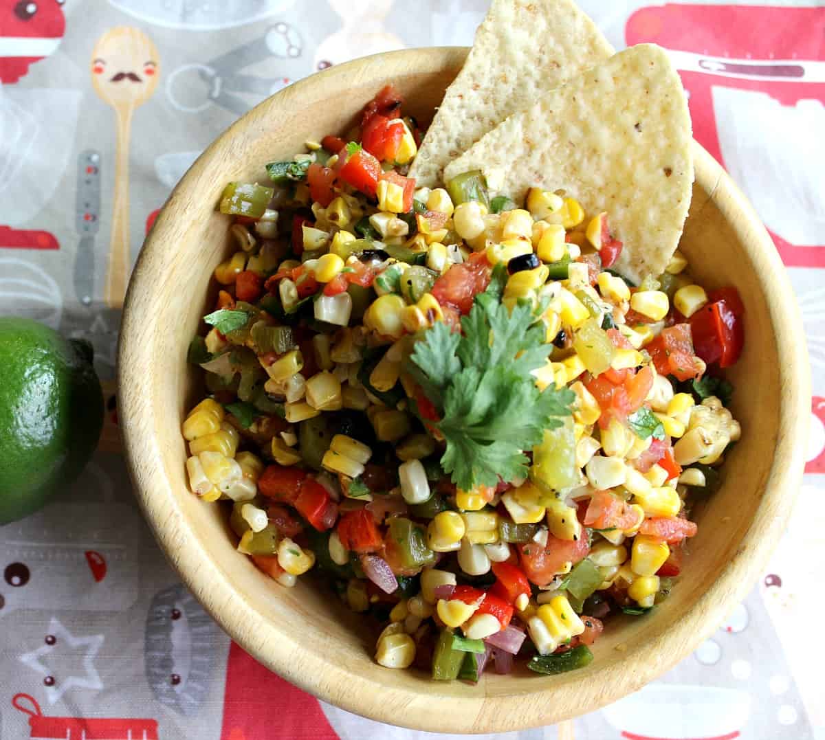 Wooden bowl holding corn and veggie salsa.