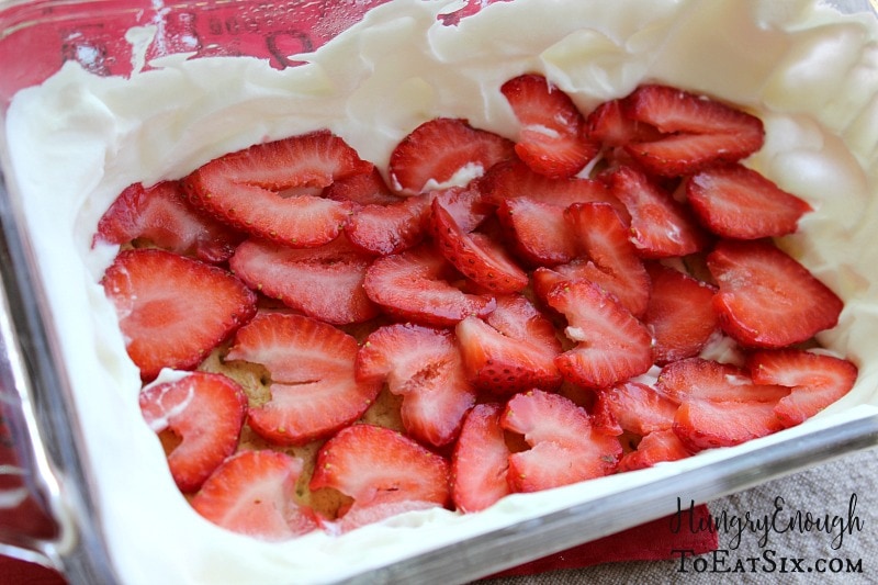 A layer of sliced strawberries over a layer of whipped cream.