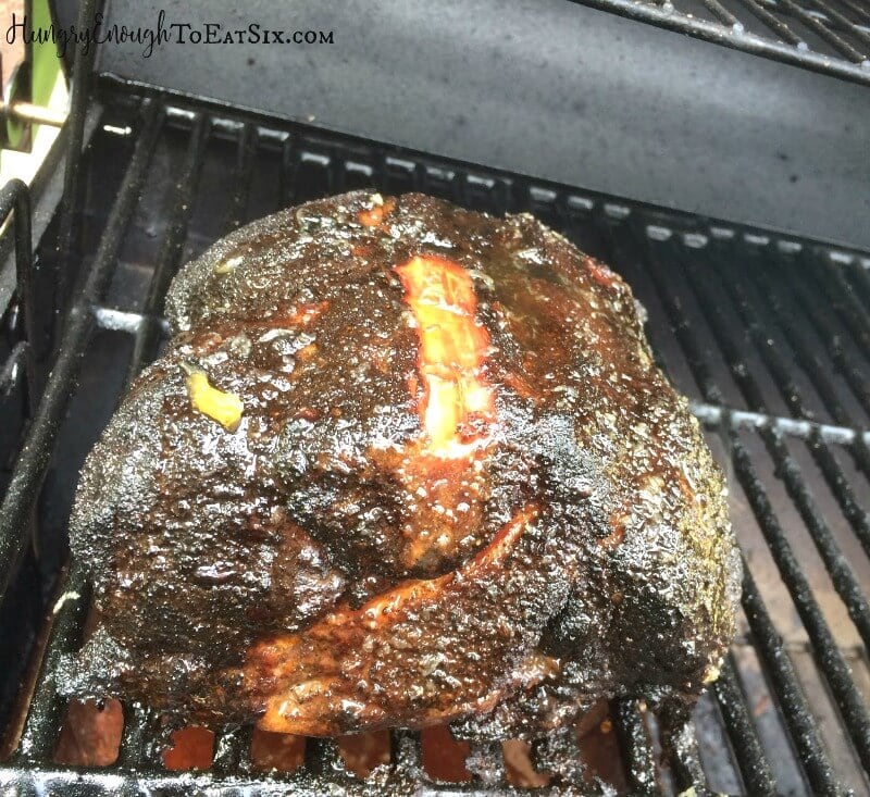 Brisket browned on the grates of a smoker.