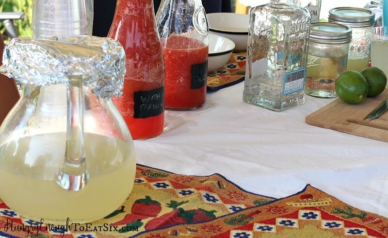 Glass decanters holding red and yellow margarita mix.
