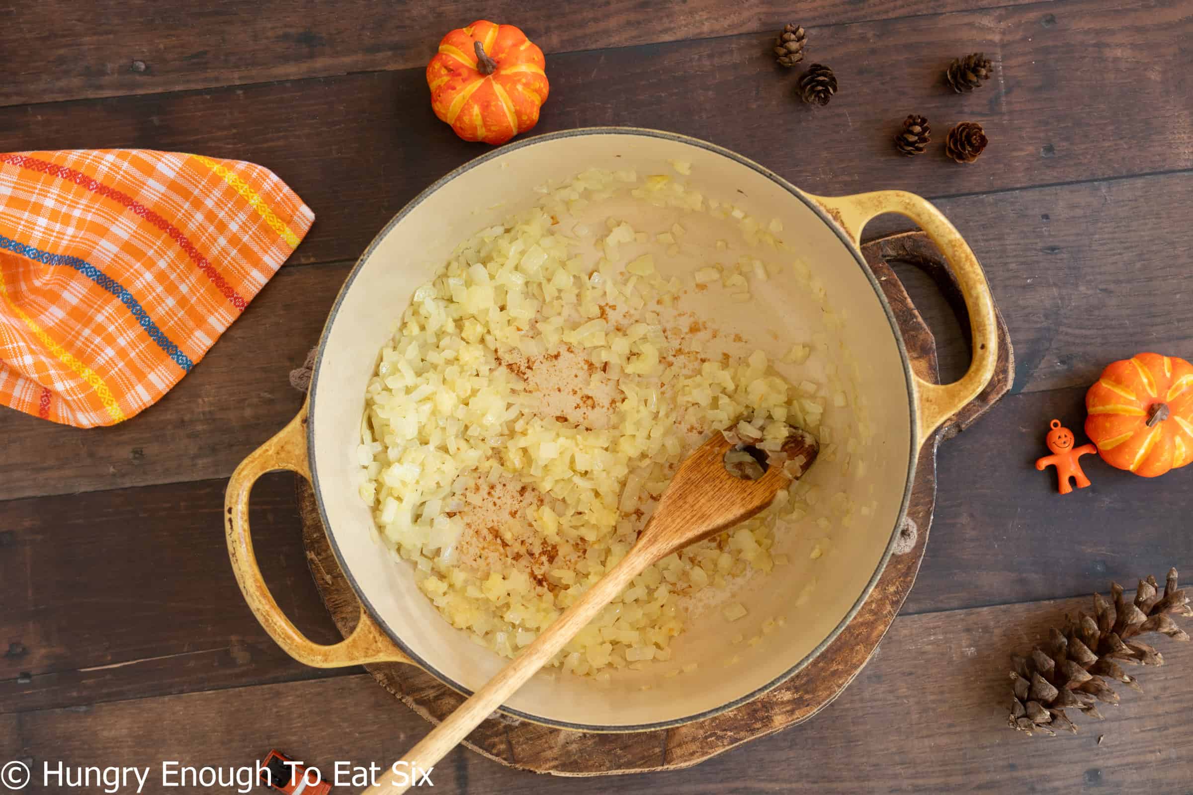 Large Dutch oven with diced onions sauteeing in oil.
