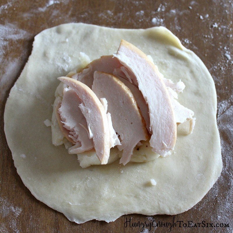 Pastry disk with potatoes and turkey layered on
