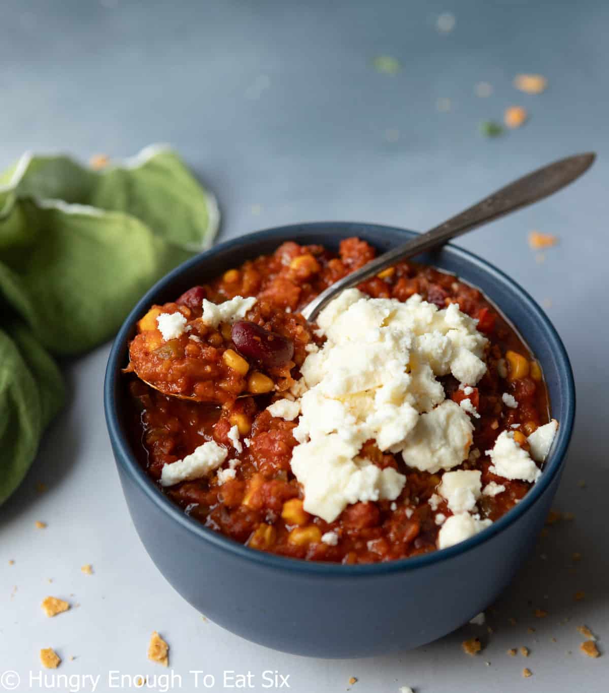 Chili in a bowl with cheese on top.