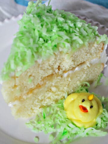 Frosted slice of layer cake with yellow frosting chick.