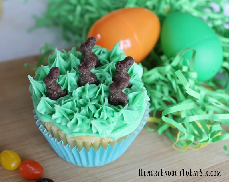 Easter surprise cupcake: yellow cupcake with green frosted top and tiny chocolate rabbits.