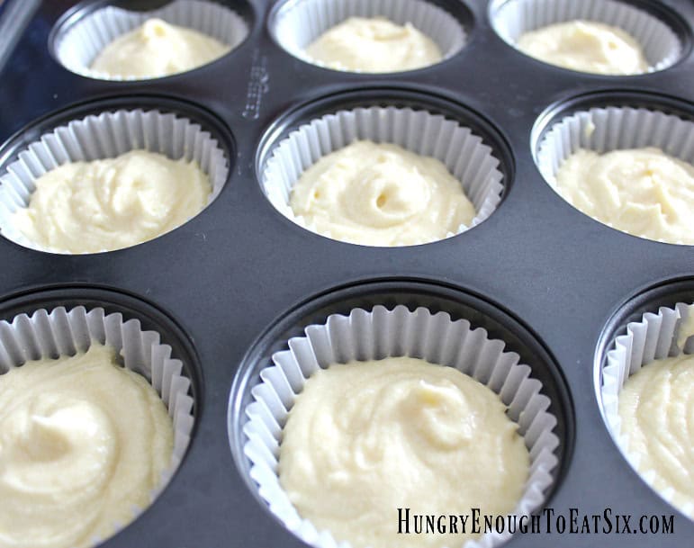 Cupcake pan wells filled with yellow cake batter for Easter Surprise Cupcakes.