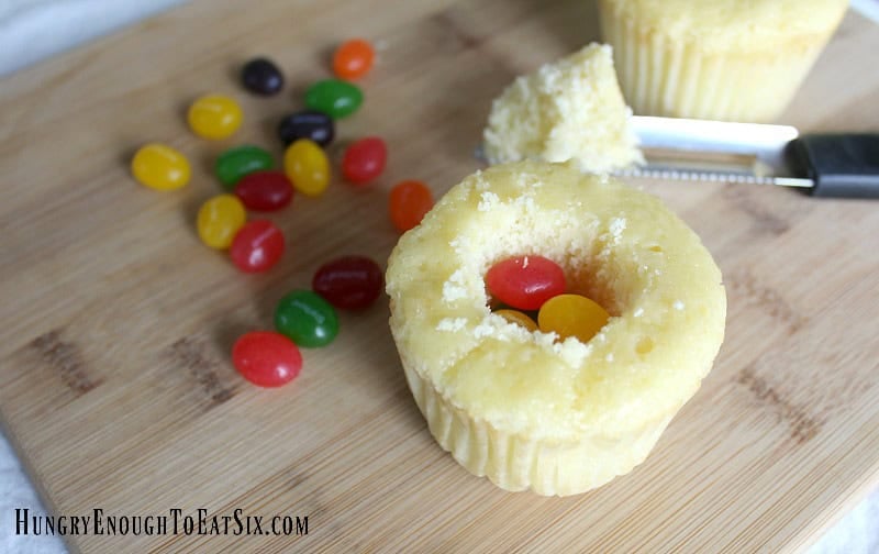 Hollowed out yellow cupcake with jelly beans inside to make Easter Surprise Cupcakes.
