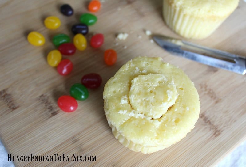 Yellow cupcake with center hollowed and covered, to make Easter Surprise Cupcakes.
