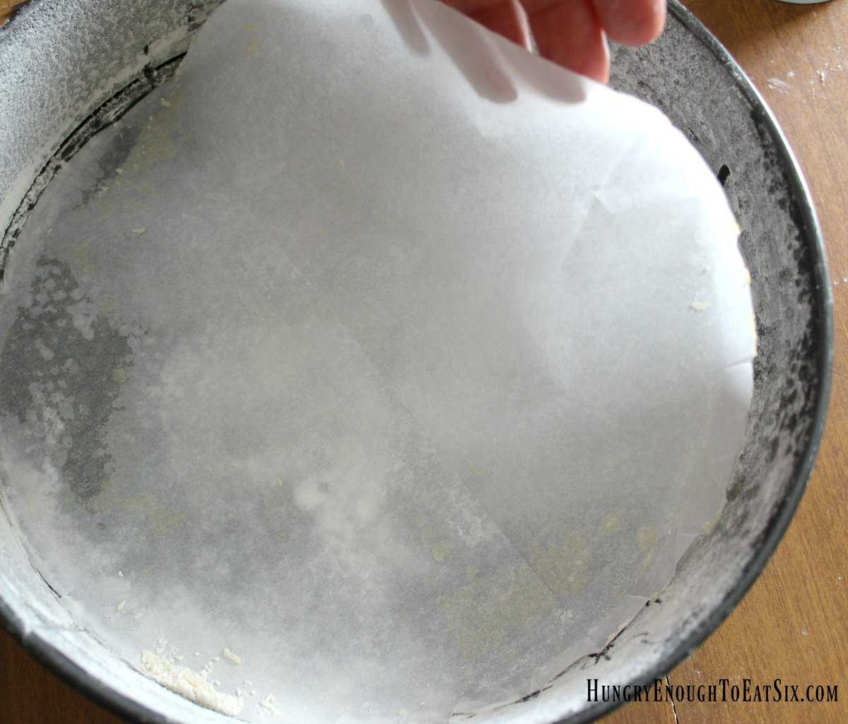 Round cake pan with parchment paper circle.
