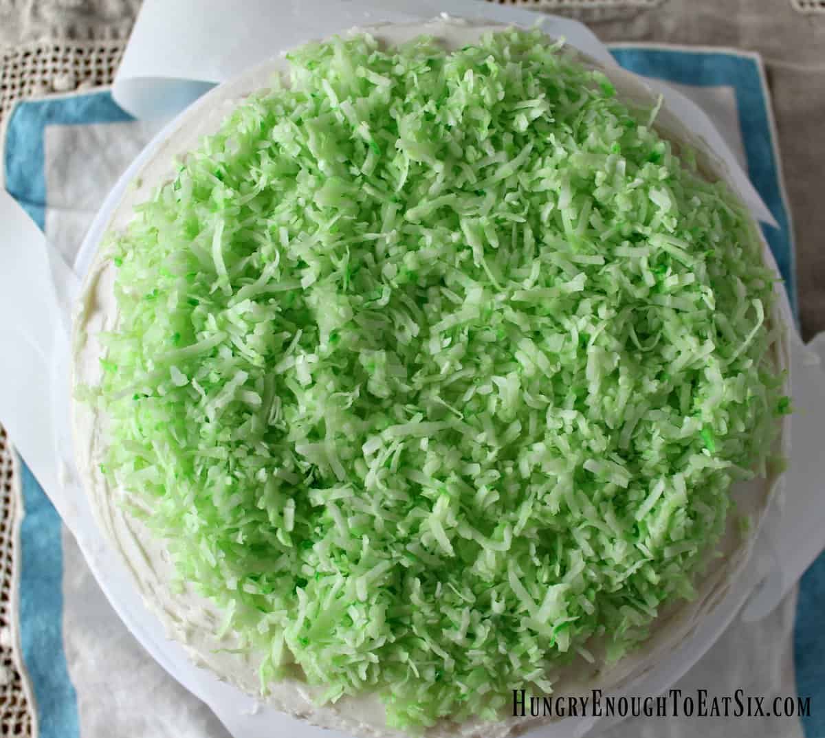 Green shredded coconut on top of cake round.