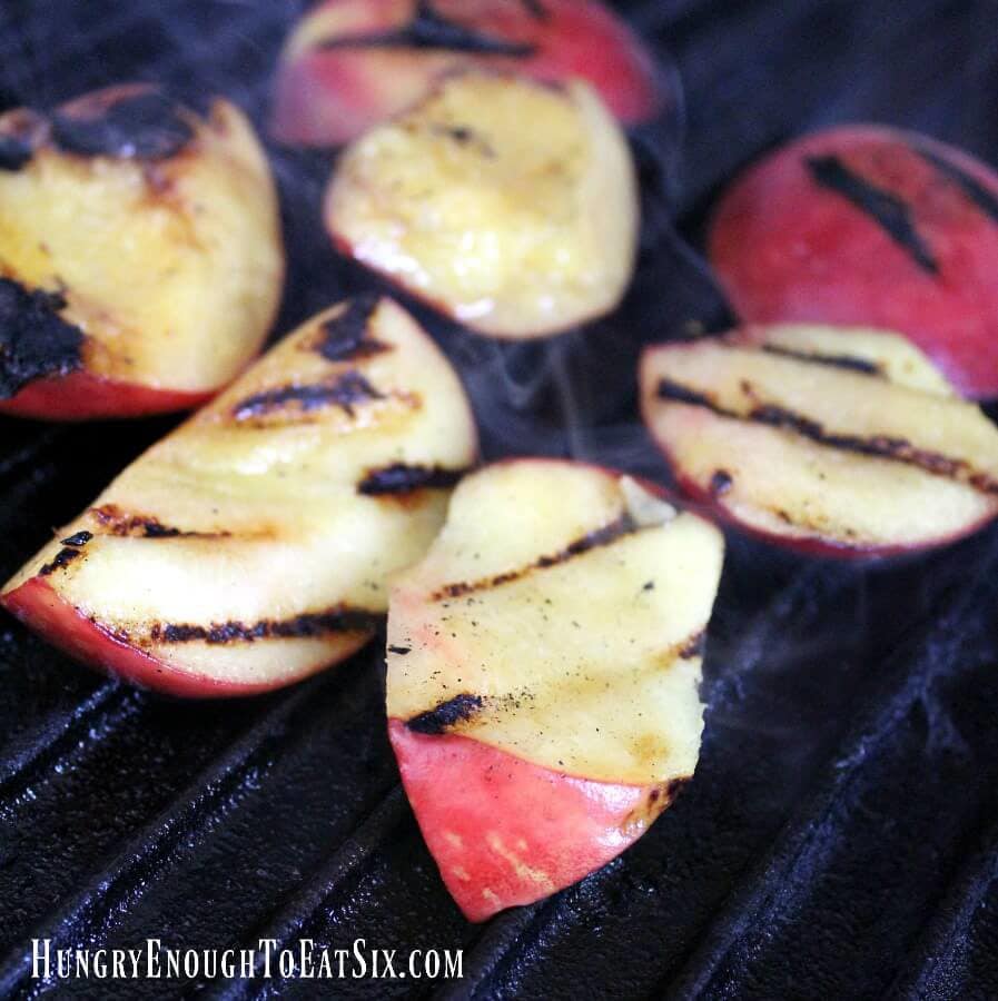 Slices of peaches on grill grates with grill marks