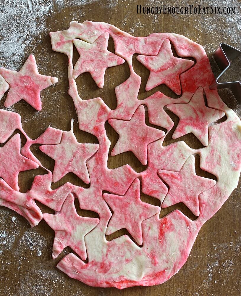 Pastry dough with red streaks throughout and star shapes cut out of the dough.