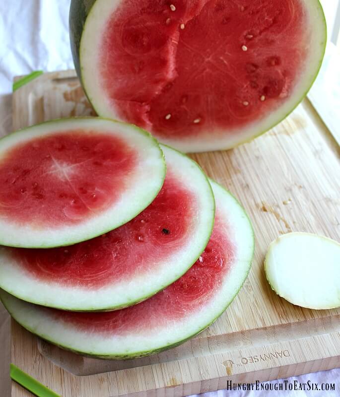 Watermelon sliced in half with slices laying on a cutting board.