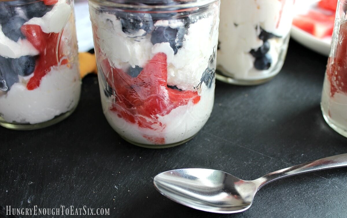 Watermelon stars and blueberries in mason jars with whipped cream.