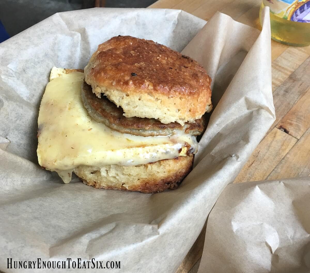 Biscuit breakfast sandwich with sausage and melted cheese.