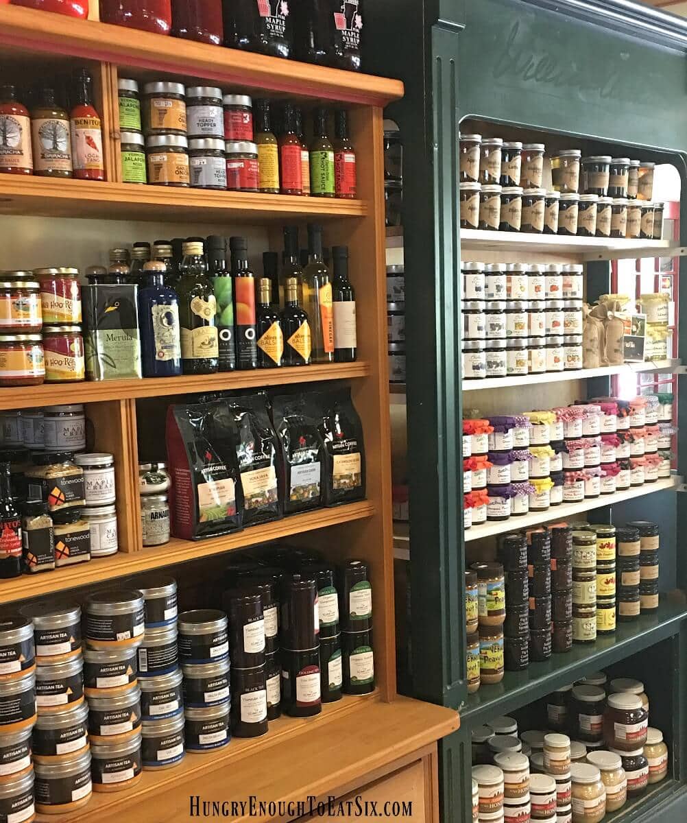Shelves holding bottles of sauces and jams, and bags of coffee beans.