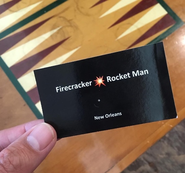 Black business card that says Firecracker - Rocket Man