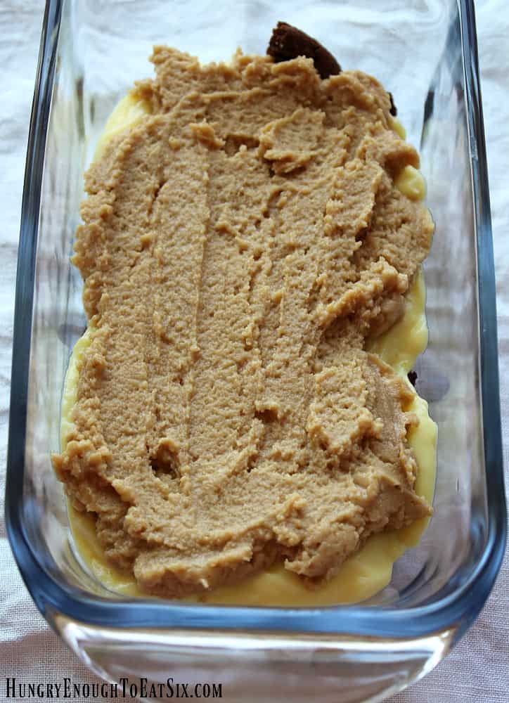 peanut butter cream cheese filling spread in a glass pan.