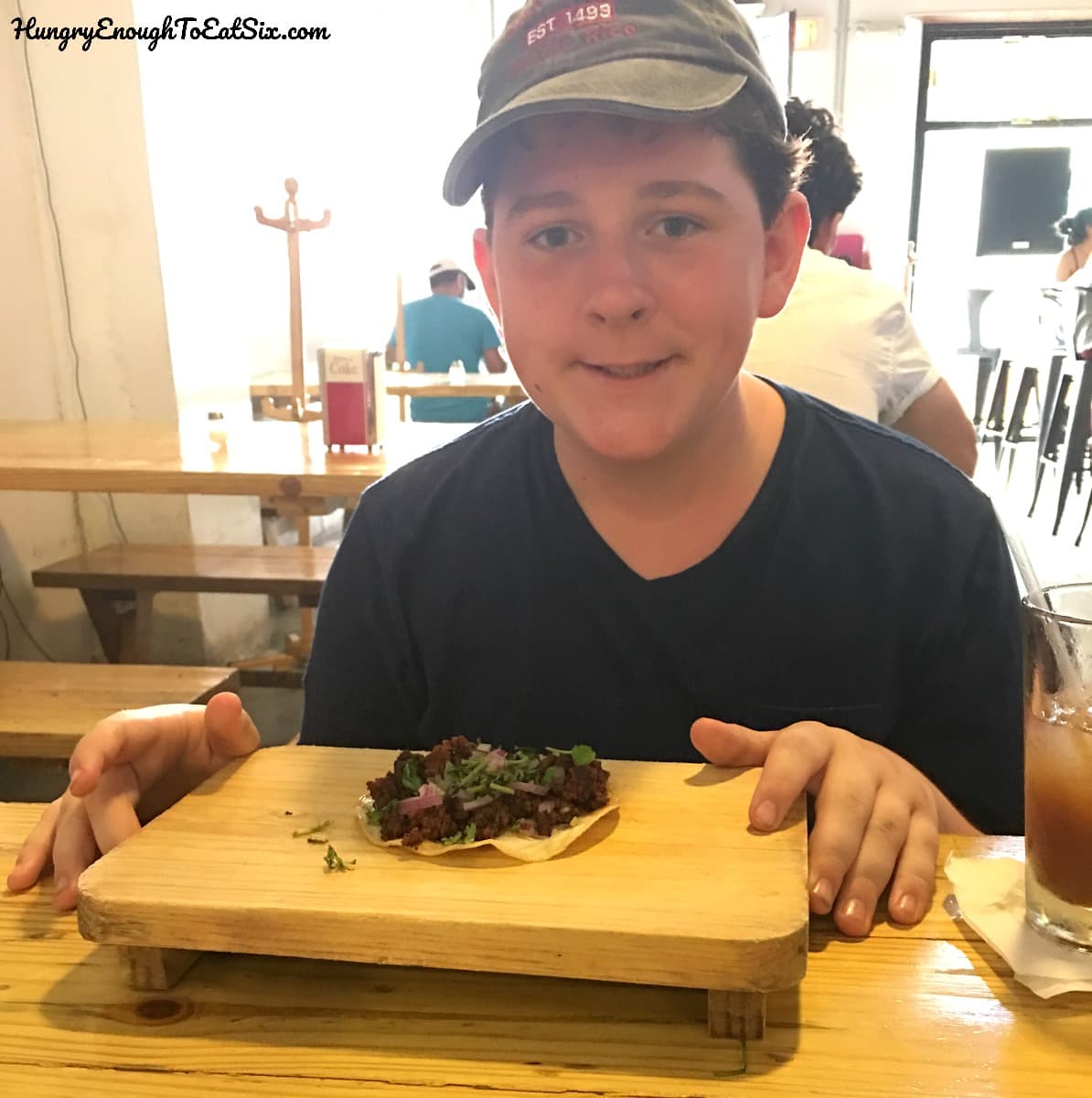 Boy with taco on a wooden board