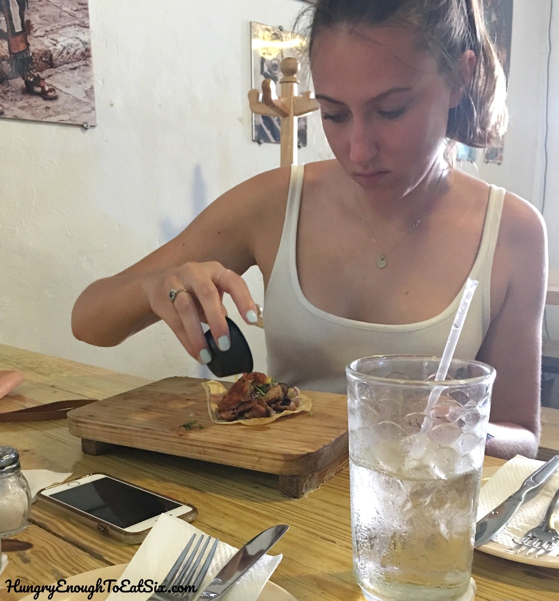 Girl pouring sauce on a taco