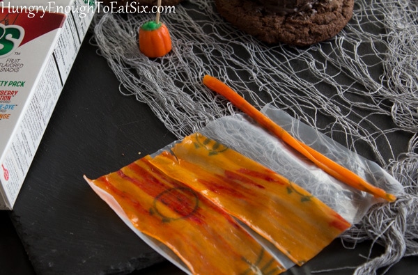 Orange and red streaked fruit roll up unrolled.