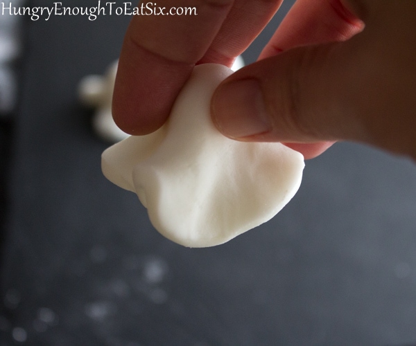 Fingers shaping a fondant ghost