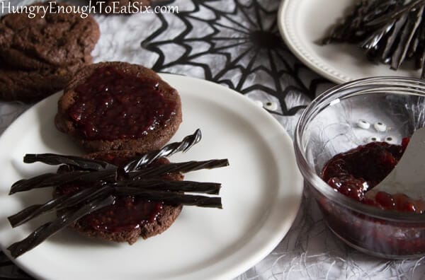 Chocolate cookies spread with jam and with black licorice arranged over it