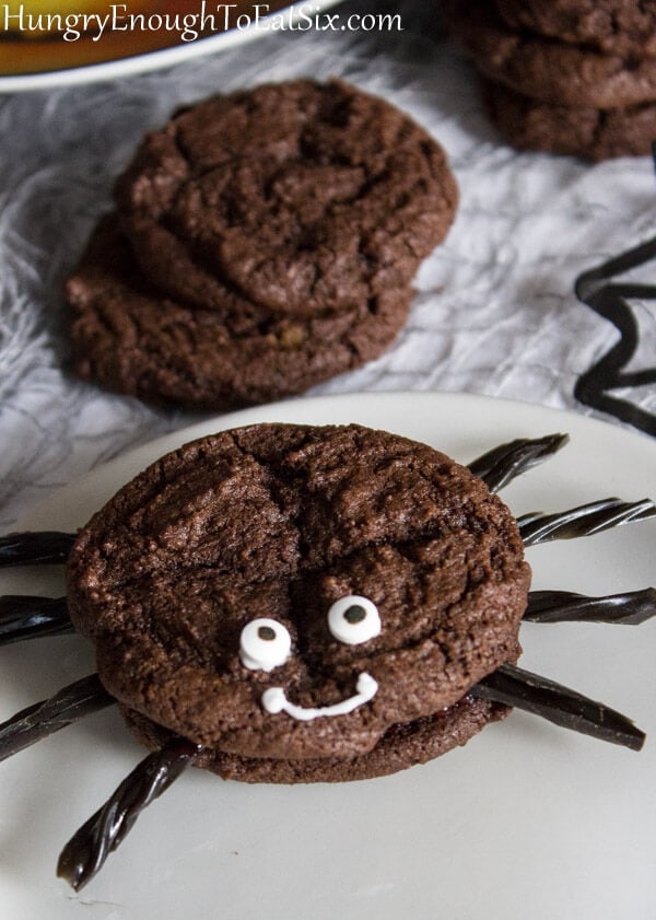Cookie sandwich made to look like a spider with candy eyes and black licorice legs