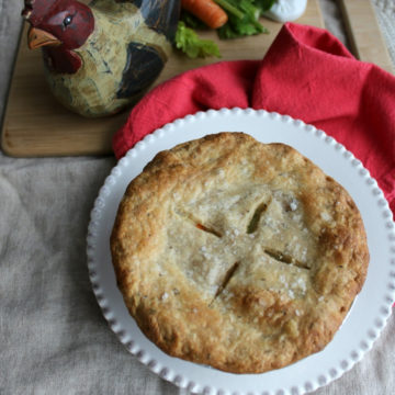 Browned pie next to a wooden chicken