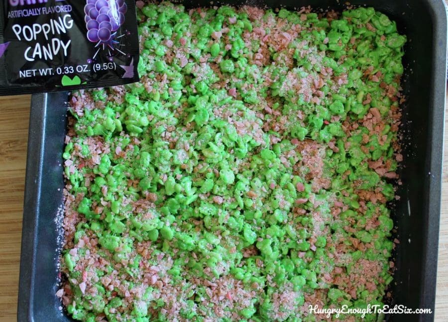 Green crispy treats pressed into a pan and topped with Pop Rocks