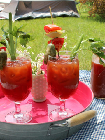 Garnished Bloody mary drinks on a metal tray