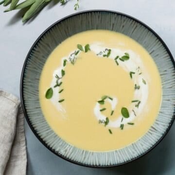 Large blue-grey bowl with corn soup and cream.