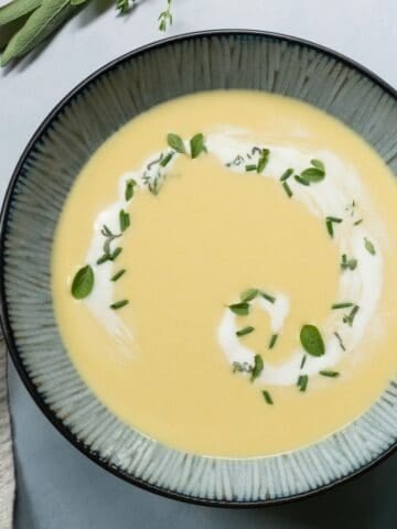 Large blue-grey bowl with corn soup and cream.