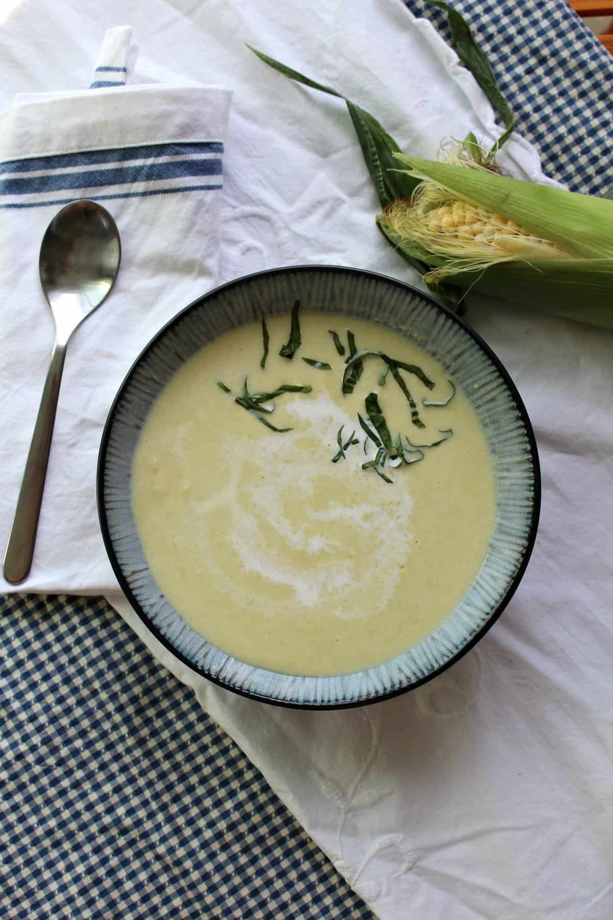 Blue-gray bowl of yellow corn soup.