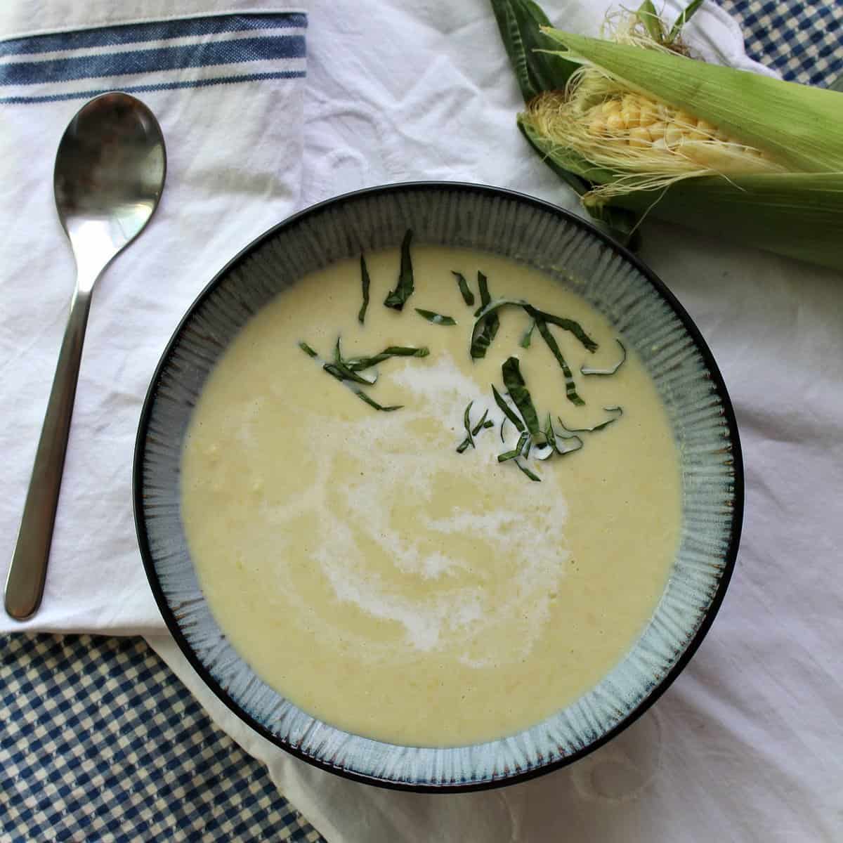 Corn soup with a cream swirl and herbs.