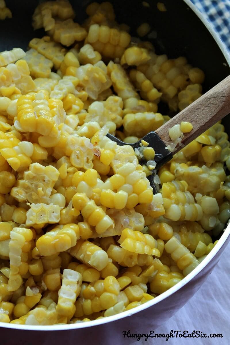 Image of corn kernels and diced shallots in a saute pan