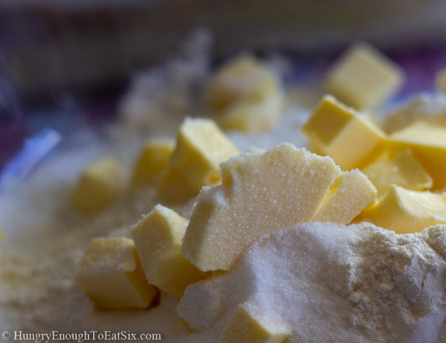 Chunks of cold butter in a flour and sugar mixture.